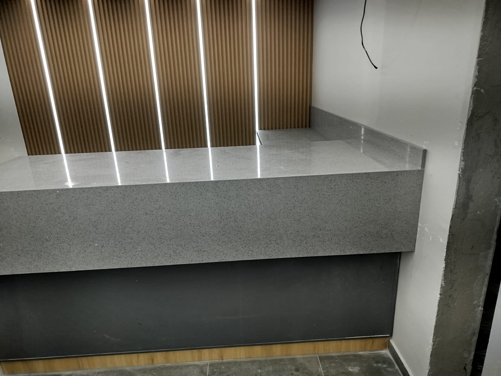 Mostrador comercial con revestimiento de listones de madera e iluminación — mobiliario para negocios Quito JOMAD